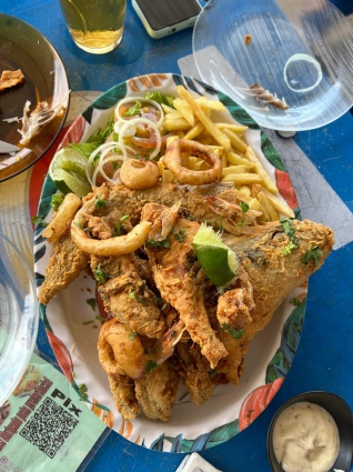 Peixe frito com anéis de lula, fritas e salada